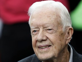 FILE - In this Oct. 23, 2016, file photo, former President Jimmy Carter sits on the Atlanta Falcons bench before the first half of an NFL football game between the Atlanta Falcons and the San Diego Chargers, in Atlanta.  Carter has been treated for dehydration while volunteering with Habitat for Humanity in Winnipeg. (AP Photo/John Bazemore, File)