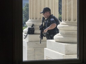 FILE - In this June 14, 2017 file photo, a Capitol Hill Police officer stands his post at the entrance to the House of Representatives on Capitol Hill in Washington. U.S. Capitol Police have investigated more threats to members of Congress in the first six months of the year than in all of 2016, says the chief law enforcement official for the House, as Majority Whip Steve Scalise remains hospitalized after a gunman opened fire at a baseball practice nearly a month ago.  (AP Photo/J. Scott Applewhite, File)