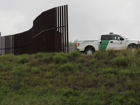 FILE - In this Nov. 13, 2016 file photo, a U.S. Customs and Border Patrol agent passes along a section of border wall in Hidalgo, Texas. The GOP-controlled House is plowing ahead on legislation to give the Pentagon a massive spending boost and deliver a $1.6 billion down payment for President Donald Trump's oft-promised wall along the U.S.-Mexico border. (AP Photo/Eric Gay, File)