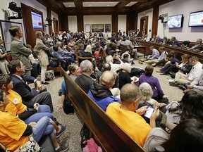 FILE - In this June 9, 2017 file photo, a packed hearing room during a Massachusetts Legislature's Committee on Public Safety and Homeland Security public hearing concerning a bill that calls for sharp limits on cooperation between federal immigration officials and state and local law enforcement agencies, at the Statehouse in Boston. The Justice Department on Thursday, July 6, 2017, questioned whether some so-called sanctuary cities responded honestly when asked whether they follow the law on sharing the citizenship status of people in their custody with federal immigration authorities. (AP Photo/Stephan Savoia, File)