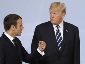 In this July 7, 2017, photo, France's President Emmanuel Macron talks with U.S. President Donald Trump after the family photo on the first day of the G-20 summit in Hamburg, Germany.