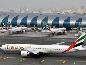 FILE - In this March 22, 2017, file photo, an Emirates plane taxis to a gate at Dubai International Airport at Dubai International Airport in Dubai, United Arab Emirates. Travelers flying to the U.S. from nearly 300 international airports, including those in Mexico and Canada, are now subject to stepped-up security measures that include stricter screening for electronic devices larger than cell phones. The new measures may include asking passengers to present larger electronic devices for inspection and prove they can be powered on.(AP Photo/Adam Schreck, File)