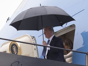 In this July 14, 2017, photo, President Donald Trump and first lady Melania Trump arrive on Air Force One at Newark Liberty International Airport, in Newark N.J., as they return from France. As Air Force One flew home from Europe, news was set to break about a meeting that Trump's eldest son had with a Kremlin-connected lawyer, promising yet another round of unwelcome headlines about the president and Russia. The day-after-day drip-drip-drip of revelations over the past week about Donald Trump Jr.'s contact with the Russian lawyer in 2016 underscores the White House's inability to shake off the Russia story and close the book on a narrative that casts a shadow over Trump's presidency.(AP Photo/Carolyn Kaster)