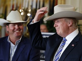 In this July 17, 2017, photo, President Donald Trump tries on a Stetson hat, as Dustin Noblitt, with Stetson Hats, smiles, during a "Made in America," product showcase featuring items created in each of the U.S. 50 states, at the White House in Washington. Stetson is base in Garland, Texas. Trump's latest effort to change the subject pulled out all the stops _ and props. (AP Photo/Alex Brandon)