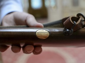 Cristian Gavrila, collectibles consignment manager at Artmark auction house, shows an engraving of Romanian Communist leader Nicolae Ceausescu's name on a Holland & Holland hunting rifle before an auction, in Bucharest, Romania, Tuesday, July 11, 2017. Romanian Communist leader Nicolae Ceausescu was an avid hunter, and his most treasured gun, a Holland & Holland hunting rifle, is to be auctioned. (AP Photo/Andreea Alexandru)