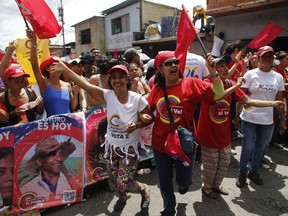 People cheer during a pro-government candidates' rally in Caracas, Venezuela, Tuesday, July 25, 2017. Across Venezuela, pro-government candidates to the Constitutional Assembly held their last campaign rallies ahead of Sunday's historical vote. (AP Photo/Ariana Cubillos)