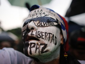 A woman with her face painted with Spanish words "Freedom, peace, don't forget" attends a vigil to honor the more than 90 people killed during three months of anti-government protests in Caracas, Venezuela, Thursday, July 13, 2017. Opposition protests demanding new elections and decrying triple-digit inflation, food shortages and worsening crime continue as President Nicolas Maduro pushes forward with his plan to draft a new constitution. (AP Photo/Ariana Cubillos)