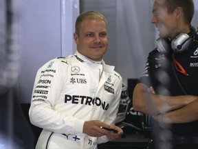 Mercedes driver Valtteri Bottas of Finland smiles in the team box before the third practice session for the Austrian Formula One Grand Prix at the Red Bull Ring in Spielberg, Austria, Saturday, July 8, 2017. The Austrian Grand Prix will be held on Sunday. (AP Photo/Ronald Zak)
