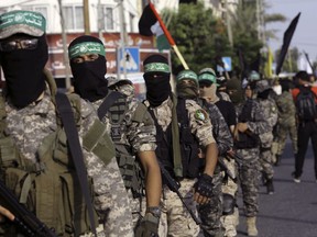 Masked militants from the Izzedine al-Qassam Brigades, a military wing of Hamas, march with their rifles during a parade against Israeli arrangements in a contested Jerusalem shrine, along the streets of Gaza City, Tuesday, July 25, 2017. Muslim leaders urged the faithful Tuesday to keep up their prayer protests and avoid entering a contested Jerusalem shrine, even after Israel dismantled metal detectors that initially triggered the tensions. (AP Photo/Adel Hana)