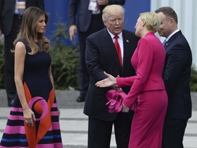 Poland's first lady Agata Kornhauser-Duda, second right, reaches her hand to U.S. First Lady Melania Trump as U.S. President Donald Trump reaches his hand for a handshake after his speech in Krasinski Square, with Polish President Andrzej Duda standing right, in Warsaw, Poland, Thursday, July 6, 2017.