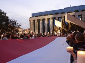 Opposition supporters shout slogans and raise candles as they protest in front of the Supreme Court, seen in the background, against a law on court control in Warsaw, Poland, Friday, July 21, 2017. The bill on the Supreme Court has drawn condemnation from the European Union and has led to street protests in Warsaw. (AP Photo/Alik Keplicz)