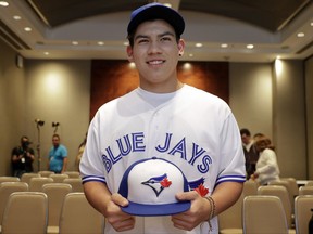 Baseball player Eric Pardinho poses for a picture wearing his new team uniform, after a signing contract in Sao Paulo, Brazil, Thursday, July 6, 2017. Brazil's 16-year-old baseball wonder signed with Toronto Blue Jays. He will spend some time in the Dominican Republic in his initial minor league steps towards Major League Baseball. (AP Photo/Andre Penner)