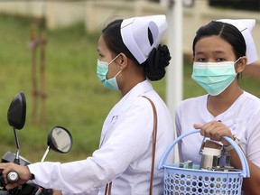Nurses cover their faces with masks to protect from the spread of the swine flu outside the Naypyitaw hospital, Tuesday, July 25, 2017, in Naypyitaw, Myanmar. Public health officials in Myanmar say that H1N1 flu, also known as swine flu, has killed three people out of 13 confirmed cases of the infection. (AP Photo/Aung Shine Oo)