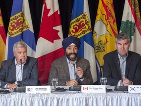 Newfoundland and Labrador Premier Dwight Ball, left, and Nova Scotia Premier Stephen McNeil, right, look on as Economic Development Minister Navdeep Bains fields a question during a news conference at an Atlantic growth strategy meeting in Steady Brook, Newfoundland and Labrador on Tuesday, July 11, 2017. THE CANADIAN PRESS/Andrew Vaughan