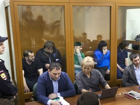 From background left: Zaur Dadayev, Temirlan Eskerkhanov, Shadid Gubashev, Khamzat Bakhayev, and Anzor Gubashe,  defendants suspected of involvement in the killing of opposition leader Boris Nemtsov, sit in a glass enclosure during their trial in a Moscow military district court in Moscow, Russia,Wednesday, July 12, 2017. A Russian jury last month found five men guilty of involvement in the killing. Prosecutors on Wednesday asked the court to sentence the suspected killer, Zaur Dadayev, a former officer in the security forces of Chechnya's leader Ramzan Kadyrov, to life in prison and the other four men to lengthy prison terms. (AP Photo/Ivan Sekretarev)