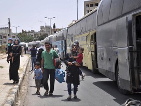 This photo released Tuesday, July 11, 2017 by the Syrian official news agency SANA, shows Syrians arriving from Jarablus, in Aleppo province, to their old neighborhood of al-Waer, in Homs, Syria. They left their homes to escape the government of Syrian President Bashar Assad, and now they are going back. Worn out by hardship and depravations of months of living in tents, about 150 Syrian families decided this week to return to the city of Homs -- even if it meant going back to a life under Assad's rule. (SANA via AP)