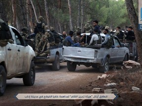 This Sunday, July 9, 2017 photo, released by Ibaa news agency, the communications arm of the al Qaeda-linked Levant Liberation Committee, that is consistent with independent AP reporting, shows al-Qaida-linked fighters gathering ahead of raids in the northwestern Syrian city of Idlib in search for members of the Islamic State group. Syrian rebels and opposition activists say an al-Qaida-linked group is on the verge of snuffing out what remains of the 2011 Syrian uprising against President Bashar Assad in northwest Syria. Arabic reads, "Convoys of Levant Liberation Committees head to carry out raids on cells of the Islamic State group in the city of Idlib." (Ibaa News Agency, via AP)