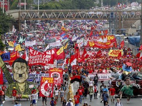 Thousands of protesters march towards the Lower House with an effigy of President Rodrigo Duterte, lower right, to demand that he deliver on a wide range of promises he made in his first state of the nation address last year, from pressing peace talks with Marxist guerrillas, which is currently on hold, to upholding human rights and the rule of law Monday, July 24, 2017 at suburban Quezon city, northeast of Manila, Philippines. It was the first time that the leftist protesters have displayed an effigy of Duterte. (AP Photo/Bullit Marquez)
