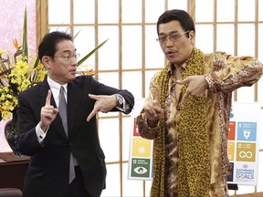 Japanese comedian Pikotaro, right, and Foreign Minister Fumio Kishida pose to raise awareness about the United Nation's 17 Sustainable Development Goals (SDGs) at the ministry in Tokyo, Wednesday, July 12, 2017. Pikotaro, who has gained global fame with his "pen-pineapple-apple-pen" song, will debut at the United Nations with a new version of PPAP to promote sustainable development. Pikotaro, appointed by the Foreign Ministry to promote U.N. sustainable development goals, recently created a SDGs version of the PPAP song. (AP Photo/Eugene Hoshiko)