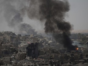 Smoke billows from Islamic State positions on the edge of the Old City a day after Iraq's prime minister declared "total victory" in Mosul, Iraq, Tuesday, July 11, 2017. (AP Photo/Felipe Dana)