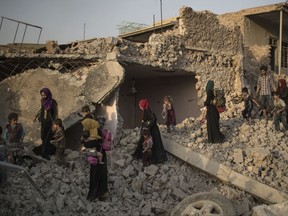 Iraqi civilians flee through the rubble of destroyed houses in the Old City of Mosul, Iraq, Tuesday, July 4, 2017. As Iraqi forces continued to advance on the last few hundred square kilometers of Mosul held by the Islamic State group, the country's Prime Minister said Tuesday the gains show Iraqis reject terrorism. (AP Photo/Felipe Dana)