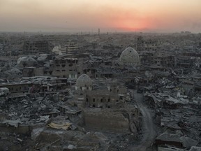 In this July 11, 2017 photo, the sun sets behind destroyed buildings in the west side of Mosul, Iraq. The 9-month fight to defeat the Islamic State group in Mosul ended in a crescendo of devastation: bombardment that damaged or destroyed a third of its historic Old City in just three weeks. The cost of uprooting the militants was the destruction of large swaths of Iraq's second largest city, leaving a population that is displaced, exhausted and potentially embittered if there is no reconstruction. (AP Photo/Felipe Dana)