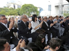Newly-named Supreme Court justices applaud before they are sworn-in at an outdoor ceremony in Caracas, Venezuela, Friday, July 21, 2017. Venezuela's opposition-led National Assembly has sworn in new magistrates to the government-dominated Supreme Court during a ceremony held in a public plaza. They appointed the slate of judges in an escalating fight against President Nicolas Maduro's plan to rewrite the constitution. (AP Photo/Fernando Llano)