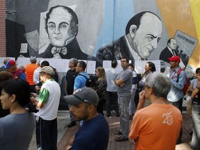 People lineup to enter to a poll station during the election for a constitutional assembly in Caracas, Venezuela, Sunday, July 30, 2017.