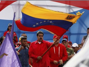 Venezuela's President Nicolas Maduro waves the Venezeulan flag during a rally in Caracas, Venezuela, Thursday, July 27, 2017.