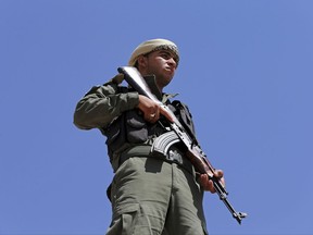 A Syrian Internal Security Forces soldier stand guards as his comrades attend their graduation ceremony, at Ain Issa desert base, in Raqqa province, northeast Syria, Thursday, July 20, 2017. Some 250 residents of Syria's Raqqa province are the latest batch to graduate from a brief U.S-training course that is preparing an internal security force to hold and secure areas as they are captured from Islamic State militants.(AP Photo/Hussein Malla)