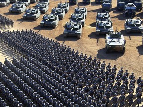 Photo released by China's Xinhua News Agency, Chinese People's Liberation Army (PLA)  troops march past military vehicles Sunday, July 30, 2017 as they arrive for a military parade to commemorate the 90th anniversary of the founding of the PLA on Aug. 1 at Zhurihe training base in north China's Inner Mongolia Autonomous Region