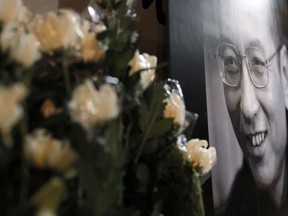 A portrait of jailed Chinese Nobel Peace laureate Liu Xiaobo is displayed for mourning during a demonstration outside the Chinese liaison office in Hong Kong, Thursday, July 13, 2017. Officials say China's most prominent political prisoner, Nobel Peace Prize laureate Liu Xiaobo, has died. He was 61. (AP Photo/Kin Cheung)