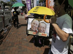 Protesters display portrait of jailed Chinese Nobel Peace laureate Liu Xiaobo and his detained wife Liu Xia during a demonstration outside the Chinese liaison office in Hong Kong, Tuesday, July 11, 2017. Chinese doctors were working to treat critically ill Liu, as the government hardened its position against growing pleas to allow China's best-known political prisoner to leave for treatment overseas. (AP Photo/Kin Cheung)