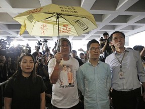 Pro-democracy Hong Kong lawmakers of the legislature council, from right, Edward Yiu, Nathan Law, Leung Kwok-hung and Lau Siu-lai protest outside the High Court in Hong Kong, Friday, July 14, 2017. Four lawmakers were disqualified by court as they failed to take their oaths correctly in last year's elections during the day of the initial Legislative Council swearing-in ceremony. (AP Photo/Kin Cheung)