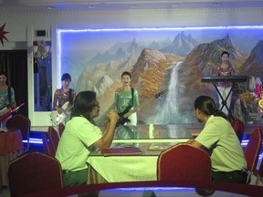 In this Tuesday, July 25, 2017 photo, waitresses sing at the Pyongyang Okryu-Gwan North Korean Restaurant in Dubai, United Arab Emirates. From state-run restaurants to construction sites, North Korean workers in Kuwait, Oman, Qatar and the United Arab Emirates face conditions akin to forced labor while being spied on by planted intelligence officers, eating little food and suffering physical abuse, authorities say. (AP Photo/Kamran Jebreili)