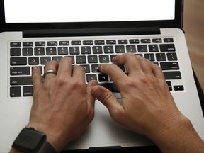 FILE - In this June 19, 2017 file photo, a person works on a laptop in North Andover, Mass. Mexican authorities say the U.S. Department of Homeland Security has instituted heightened security measures for laptops and tablets on U.S.-bound flights from Mexico, starting Wednesday, July 19, 2017. (AP Photo/Elise Amendola, File)