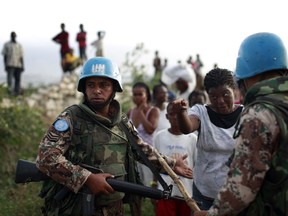 FILE - In this Feb. 3, 2010 file photo, a woman speaks to U.N. peacekeepers during a food distribution at a refugee camp in Port-au-Prince, Haiti, following a powerful earthquake on Jan. 12. Top U.N. official for Haiti, Sandra Honore, said on Thursday, July 20, 2017 peacekeepers have accomplished their mission of stabilizing the Western hemisphere's poorest nation. Honore said Haiti today "is far different" than it was in 2004, when the U.N. deployed peacekeeping troops following a rebellion that left the country on the brink of collapse. (AP Photo/Rodrigo Abd, File)