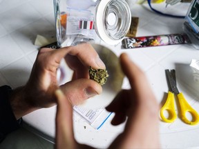 FILE - In this July 16, 2016 file photo, a competitor looks at a marijuana bud through a magnifying glass at the fifth annual Cannabis Cup, a competition for best marijuana, in Montevideo, Uruguay.  Legal sales of marijuana for recreational purposes are set to begin in Uruguay at a limited number of pharmacies, to nearly 5,000 people who have registered as consumers, the South American nation's Cannabis Regulation and Control Institute said Friday, July 14, 2017. (AP Photo/Matilde Campodonico, File)