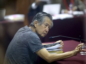 FILE - In this April 23, 2014 file photo, jailed former Peruvian President Alberto Fujimori, photographed through a glass window, attends his trial at a police base on the outskirts of Lima, Peru. President Pedro Pablo Kuczynski said Friday, July 7, 2017, that a group of doctor's will help him determine whether to grant a medical pardon for the country's imprisoned former leader. (AP Photo/Martin Mejia, File)
