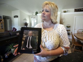 FILE - In this July 13, 2016 file photo, Laurie Holt holds a photograph of her son Joshua Holt, who has been jailed in Venezuela, at her home in Riverton, Utah. Venezuela's chief prosecutor has requested the conditional release of the Utah man and his wife detained for over a year on weapons charges. announced on Friday, July 14, 2017. (AP Photo/Rick Bowmer, File)
