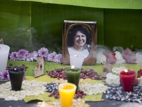 FILE - This June 15, 2016, file photo shows a framed image of environmentalist Berta Caceres on a makeshift altar made in her honor during a demonstration outside Honduras' embassy, in Mexico City. At least 200 land and environmental defenders were slain protecting forests, rivers and lands from mining, logging and agricultural companies in 2016 in the world's deadliest recorded year for such activists, a watchdog group said Thursday, July 13, 2017. That included the high-profile murder of Caceres, who was awarded the prestigious Goldman Environmental Prize for her opposition to a hydroelectric project on her Lenca people's lands in Honduras. (AP Photo/Eduardo Verdugo, File)