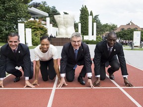 From left to right, Eric Garcetti, Mayor of Los Angeles, Allyson Felix, US Sprinter, International Olympic Committee, IOC, President Thomas Bach from Germany, and Michael Johnson, former US Sprinter, pose on the 200m track during a visit of the Los Angeles 2024 Candidate City delegation, at the Olympic Museum, in Lausanne, Switzerland, Monday, July 10, 2017. (Jean-Christophe Bott/Keystone via AP)