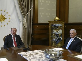 Turkey's President Recep Tayyip Erdogan, left, meets with Turkey's Prime Minister Bibali Yildirim, right, in Ankara, Turkey, Wednesday, July 19, 2017. (Presidency Press Service via AP, Pool)