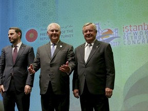 U.S. Secretary of State Rex Tillerson, centre, gestures as he poses for photographs with the World Petroleum Congress President Jozsef Toth, right, and Turkey's Energy Minister Berat Albayrak, left, at the World Petroleum Congress, hosted by Istanbul, Turkey, Sunday, July 9, 2017.  Toth, described Tillerson, who is from Texas, as "a man born with oil in his veins" before presenting him with the Dewhurst Award, named after the founder of the congress. The former ExxonMobile chief expressed his gratitude and said he misses "colleagues, partners and competitors" in the oil industry. (AP Photo)