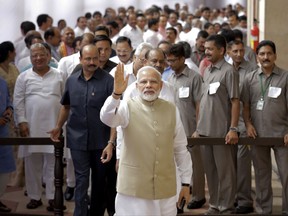 Indian Prime Minister Narendra Modi, center, waves to media after casting his vote for the president election at the parliament house in New Delhi, India, Monday, July 17, 2017. Lawmakers were voting Monday to choose India's next president in an election likely to be won by a little-known member of a Hindu political group that is closely allied to India's ruling Bharatiya Janata Party. (AP Photo/Manish Swarup)