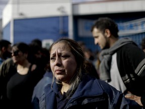 Vanina Roda stands next to her team workers after clashes with police outside the PepsiCo plant on the outskirts of Buenos Aires, Argentina, Thursday, July 13, 2017. Hundreds of police and security agents clashed Thursday with the former PepsiCo employees after resisting eviction from the plant outside Buenos Aires. Workers had occupied the plant after PepsiCo closed the plant last month for logistical reasons. (AP Photo/Natacha Pisarenko)