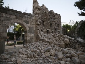 Tourists take pictures of a damage part of a wall following an earthquake in the Mediterranean island of Kos, Greece, Friday, July 21, 2017. Causing panic but little serious damage, a powerful earthquake shook vacation resorts in Greece and Turkey, hurting nearly 500 people and killing two tourists who were crushed when a building collapsed on a popular bar in the Greek island of Kos.(AP Photo/Petros Giannakouris)