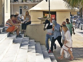 Policeman in plain clothes lead two suspects , center, as they enter the court in Zakynthos island, Greece, Tuesday, July 11, 2017. Eight suspects charged with involvement in the beating death of a 22-year-old American tourist on a Greek island were granted brief delays in court appearances Tuesday to allow their lawyers to prepare their cases, while authorities have arrested a ninth man. The hearings for six Serbs, a British citizen of Serb origin and a Greek were postponed for Wednesday and Thursday. (imerazande.gr via AP)