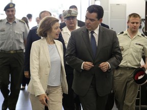 Cyprus' defense minister Christoforos Fokaides, right, walks with his French counterpart Florence Parly at the joint rescue coordination center inside the airport in southern costal city of Larnaca, Monday, July 17, 2017. Parly is in Cyprus for one-day visit during her tour in the eastern Mediterranean region. (AP Photo/Petros Karadjias)