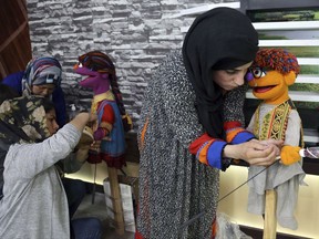 In this Monday, July 10, 2017 photo, Afghan puppeteers setting props for Sesame Street's new Afghan character, a 4-year-old Afghan puppet boy called Zeerak, right, and Zari, before a recoding a segment for Afghan version of Sesame Street called Baghch-e-Simsim for the sixth season of the program aired on TOLO a Local Television station in Kabul, Afghanistan. (AP Photo/Rahmat Gul)